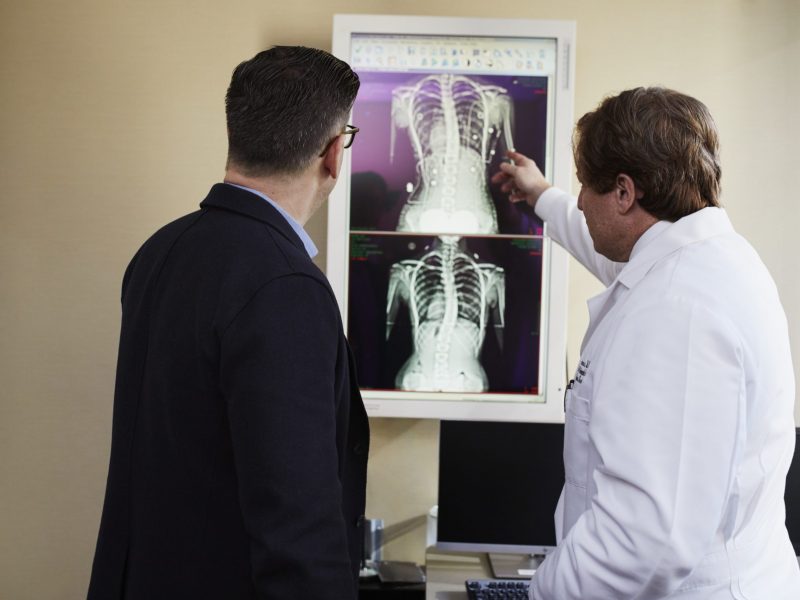 doctor-pointing-x-ray-result-beside-man-wearing-black-suit-2182972.jpg